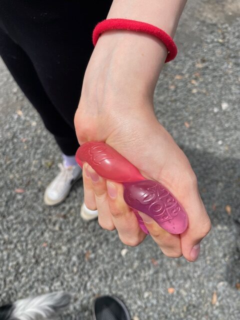 Pink and Blue Stress Cubes being squished in a hand
